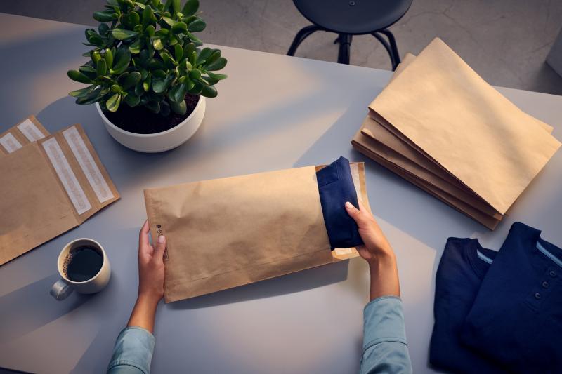 Händer packar tröja i iamKraft ePack.